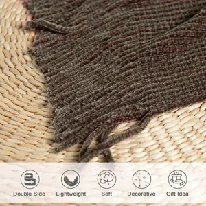 Close-up detail of the dark brown knitted throw blanket texture, showing soft ribbed fabric.