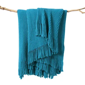 Teal knit throw blanket detail showing soft textured fabric with elegant bottom fringe design.