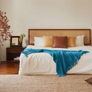 Blue knitted throw blanket detail showcasing waffle texture and fringe on cozy bed scene.