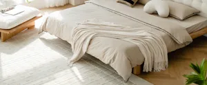Cozy beige knitted throw blanket draped gracefully on bed in a bright modern bedroom setting.