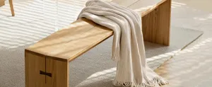 Beige ribbed knit throw blanket detail showing soft textured fabric and elegant fringe edges.