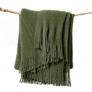 Olive green knitted throw blanket with fringe draped on branch for sofa living room decor