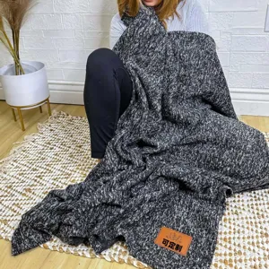 Black and white speckled knitted throw blanket lifestyle main image showing cozy home decor.