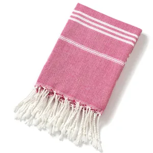 Telo mare turco rosa con strisce bianche tessute e frange intrecciate eleganti.