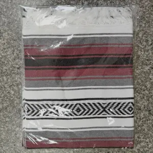 Woven Mexican blanket with geometric stripes and fringe, perfect for beach, picnic and yoga.