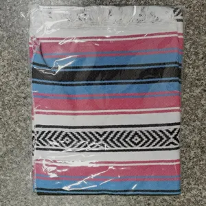 Woven Mexican blanket with geometric patterns and fringe, detailed view of texture.