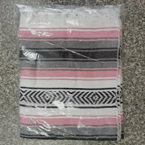 Detail view of woven Mexican style blanket with colorful stripes and fringe tassels.