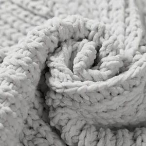 Chunky knit blanket texture detail close up, soft cozy throw blanket fabric closeup