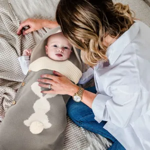 Detailansicht des Babystrick-Schlafsacks mit Kapuze, Hasen-Design und hübschen Holzknöpfen.