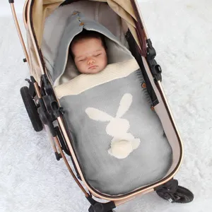 Detailansicht des niedlichen gestrickten Baby-Schlafsacks mit Hasenohren im Kinderwagen.