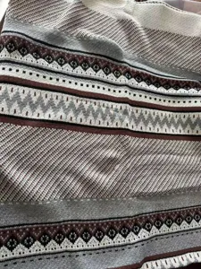Close-up detail of woven knit jacquard blanket with vintage bohemian geometric pattern.