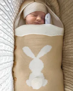 Detailaufnahme des gestrickten Babyschlafsacks mit niedlichem Hasenmotiv und warmer Wolle.