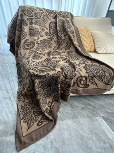 Couverture plaid jacquard tissée douillette sur canapé, texture détaillée, idéale pour la sieste.