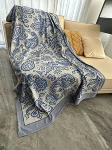 Vue détaillée du plaid de canapé tissé jacquard confortable avec motif cachemire bleu classique.