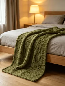 Chunky knit green blanket cozy bedroom scene warm lighting textured throw blanket soft bedding