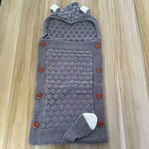 Detailed view of the gray knitted baby sleeping bag with cute animal ears and wooden buttons.
