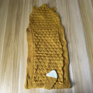Knitted baby sleeping bag detail showing cute tail and ear design with soft texture.