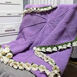 Detailed view of the handmade purple crochet blanket featuring elegant white rose flower borders.