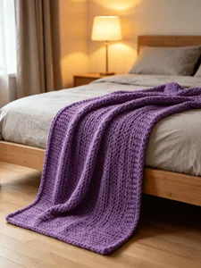 Cozy purple chunky knit blanket on a bed, showcasing soft chenille texture and home decor.