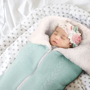 Cozy knitted baby sleeping bag with soft fleece lining, breathable swaddle blanket for infants.