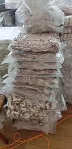 Detail view of compressed vacuum-packed leopard print flannel blankets in warehouse storage.