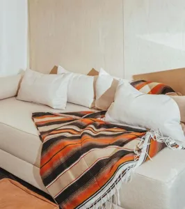 Woven Mexican blanket with fringe, colorful striped design, ideal for sofa throw or picnic mat.