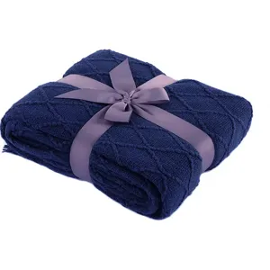Dark blue knitted blanket with ribbon bow, cozy throw for sofa and bed decoration use.