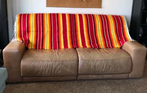 Detailed view of traditional colorful Mexican serape blanket with fringe for home decor.
