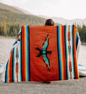 Woven Mexican blanket with vibrant tribal thunderbird design and fringe trim for beach and outdoor.