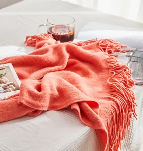 Nordic solid color orange knitted throw blanket with fringes for sofa and bed decor.