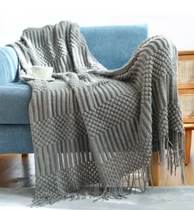 Cozy grey knitted throw blanket with geometric texture and fringe for modern sofa home decor