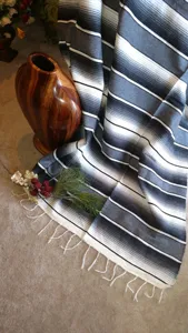Close-up detail of handmade Mexican woven serape blanket featuring stylish black and grey stripes.