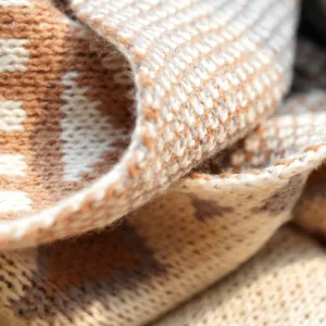 Bohemian knitted throw blanket macro texture close up cozy winter sofa home decor item.