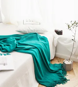 Detailed view of Nordic solid color knitted tassel blanket showcasing soft texture and cozy bedroom scene.
