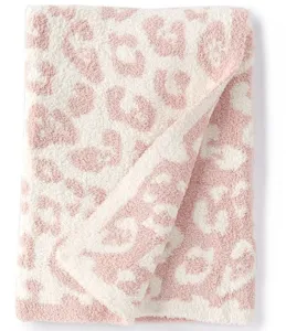 Soft pink leopard print knit throw blanket for sofa and bed, cozy fluffy texture detail.