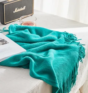 Detailed view of Nordic knitted throw blanket with fringe, soft solid color design for sofa.