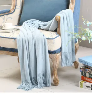 Hellblaue gestrickte Wohndecke mit Fransen, weiche Sofadecke fuer gemuetliches Wohnzimmer.