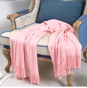 Detailansicht der rosa geflochtenen Decke auf einem Sessel, gemütliche und weiche Textur.