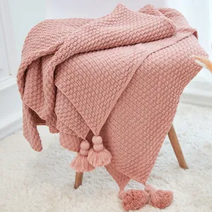 Pink knitted throw blanket with tassels and pineapple texture for cozy sofa home decor.