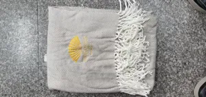 Herringbone pattern throw blanket with fringe, grey knit blanket with embroidered fan logo.