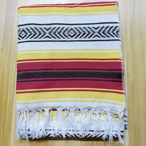 Gros plan sur une couverture mexicaine tissée à la main aux motifs géométriques colorés.