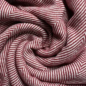 Red and white herringbone knit throw blanket close up, textured woven fabric material.