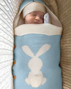 Gemütlicher Baby Strickschlafsack mit Hasenmuster und Holzknöpfen für Neugeborene.