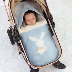 Detailaufnahme des Babyschlafsacks aus Strick für Kinderwagen mit süßem Hasenmuster und Kapuze.
