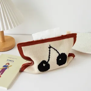 Vista detallada de funda de caja de pañuelos tejida con patrón de cereza en decoración.