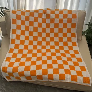 Orange and white checkered throw blanket for sofa, cozy knitted fleece blanket for home decor.