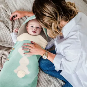 Gemütlicher Baby Strickschlafsack mit niedlicher Hasenkapuze und weichem Material.