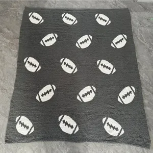 Coperta in maglia grigia con motivi da football americano, morbido tessuto felpato per divano.
