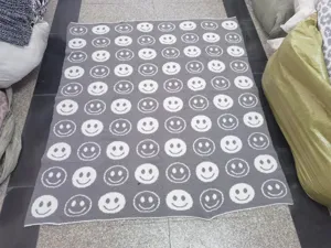 Detailansicht der gestrickten Jacquard-Wohndecke mit süßem Smiley-Muster für gemütliche Sofas