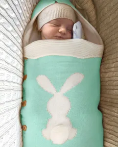 Gemütlicher mintgrüner Babyschlafsack aus Strick mit Hasen-Design und Holzknöpfen für Neugeborene.